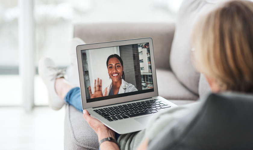 Photo-of-woman-sitting-on-couch-doing-a-telehealth-appointment-with-doctor_840x500